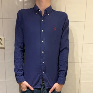 Blå skjorta från Polo Ralph Lauren - Snygg blå skjorta från Polo Ralph Lauren med rutig insida, mycket fint skick. Jag på bilden är 184cm lång och väger 70kg. Hör av er vid frågor eller funderingar!✌️👌