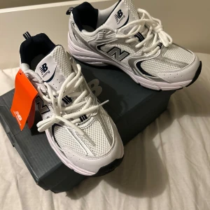 New Balance 430 Navy 42 EU - Snygga vita New Balance sneakers med silvriga och svarta detaljer. Ovandelen är i mesh och syntet för en sportig vibe, med klassisk N-logga på sidan och tjock, bekväm sula. Perfekta för dig som gillar retrostil och streetwear. Skorna har snörning och rund tå. DET VAR AI SOM SKREV DET HÄR AHHAHS , men de är storlek 42 skriv gärna ;) 😎🇸🇪skriv om ni är mellan 41-43