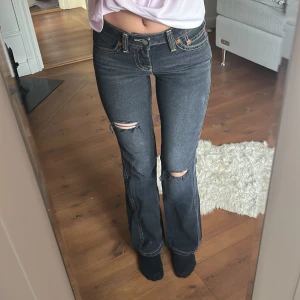 Levi's 527 svarta bootcut jeans - Säljer ett par svarta Levi's 527 jeans med bootcut passform och slitna detaljer vid knäna. Jeansen har kontrastsömmar, klassiska fem fickor och läderpatch bak. Perfekt för dig som gillar en edgy och avslappnad stil. Skit snygga jeans, SÄLJS ENDAST PGA tajt i midjan för mig ☺️ Använt 1 gång ‼️🥰