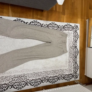 Beige mjukisbyxor från Amisu XS - Beiga mjukisbyxor från Amisu i storlek XS. Byxorna har en ribbad midja och är gjorda i ett mjukt, stickat material som är perfekt för chill dagar. De har en relaxed passform och är superbekväma att ha på sig.