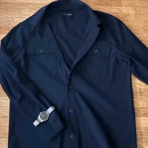 Navy blue overshirt från Matinique - ❗️lägg prisförslag❗️Stilren navy blue overshirt från Matinique med klassisk krage, två bröstfickor med knappar och raka ärmslut. Skjortan har en clean look och stängs med knappar framtill. Perfekt att bära öppen över en t-shirt för en avslappnad vibe.