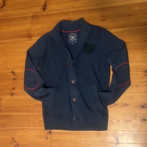 Mörkblå cardigan - En snygg cardigan i färg mörkblå. Storleken är S. Märke är S&C. Välidgt bra skick, inga hål eller defekter. Nypris runt 1200kr. Hör av dig vid flera frågor eller bilder