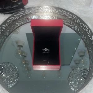 Dior ring  - Snygg silverfärgad dior ring med glittrande stenar i ett korsat, modernt mönster. Ringen har en elegant och stilren design som verkligen sticker ut. Perfekt för dig som gillar smycken med lite extra bling och unik form. (Tyvärr har jag tappat bort originalboxen)!!! Finns mer än en!!!