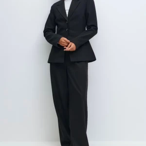 Svart kavaj från Gina Tricot, blazer  - Klassisk svart kavaj från Gina Tricot med två knappar framtill och figursydd passform. Kavajen har smala slag, två fickor och är tillverkad i ett mjukt polyestertyg. Perfekt för en stilren och clean look. Orginalpris 699kr