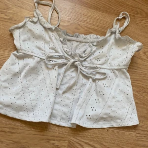 Vit blus med snörning och spetsdetaljer - Snygg vit topp vet inte vart den är ifrån fick den av min syrra det står ingen strorlek men passar nog runt 156/158/164 man kan justera banden och knyta så som man vill. Säljer pga aldrig använt 