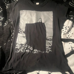 TORVENIUS t-shirt - Svart t-shirt från TORVENIUS med ett stort grafiskt tryck framtill som föreställer ”Döden”. Klassisk passform och rund hals. Perfekt för dig som gillar unika och lite mörkare motiv.