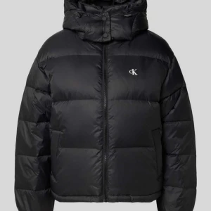 Svart pufferjacka från Calvin Klein - Säljer en svart pufferjacka från Calvin Klein med huva och dragkedja framtill. Man känner sig varm med denna på vintern och fryser ALDRIG! Jackan har en clean look med diskret CK-logga på bröstet och är quiltad för extra värme. Perfekt för kalla dagar och har en snygg, lite boxig passform. Obs!! Lånad bild på slide 2 men kan skicka mer bilder vid förfrågan. Köpt för 2700 i Calvin Kleins officiella hemsida men säljer för 1700 🥰💞💞