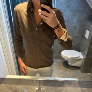 Brun långärmad piké/skjorta John Henric - Säljer nu en riktigt schysst långärmad piké från John Henric. Tröjan har en snygg och höstig brun färg. Jag är 188cm och bör storlek M på bilden. Tröjan är i riktigt bra skick och har inga defekter. Hör av er vid funderingar;)