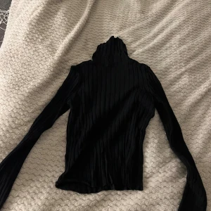 Svart ribbad polotröja från H&M XS - Svart ribbad polotröja från H&M i storlek XS. Tröjan har lång ärm och hög polokrage! 🥰