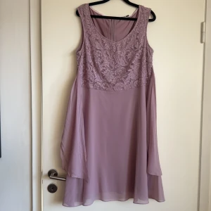 Ljuslila spetsklänning med knytband - Superfin ljuslila klänning från Esprit  med vacker spets upptill och flowy kjol i chiffong. Ärmlös modell med rundad halsringning och dekorativt knytband i midjan. Perfekt för dig som vill ha en feminin och elegant look. Storlek 42, 44