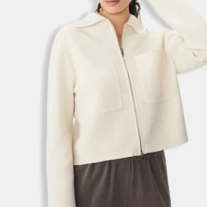 Vit croppad overshirt från ARKET - Minimalistisk vit overshirt från ARKET med croppad passform, två stora bröstfickor och hel dragkedja framtill. Jackan har klassisk krage och är tillverkad i ett mjukt material som ger en clean och modern look.