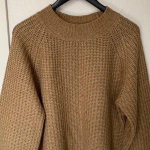 Beige stickad tröja från 157 - Säljer en chunky stickad tröja i beige från 157. Tröjan har grov struktur, rund halsringning och långa ärmar. Perfekt för lager-på-lager och chill höst- och vinterdagar. Superenkel att styla med jeans eller kjol.