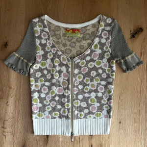 Supercool tröja - Supercool Eva & Claudi tröja med dragkedja och korta ärmar. Köptes secondhand men inga tydliga defekter. Säljer den då den inte är min stil. OBS! Storlek uppskattad.