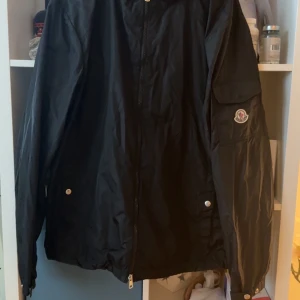 Moncler Etiache Giubbotto - Säljer min exklusiva Moncler Etiache Giubbotto i storlek 5. Använd ca 6 månader, i mycket fint skick. Endast en knapp saknas på ärmfickan, men medföljer original extra knapp för enkel ersättning. Nypris betydligt högre, här får du chansen till ett riktigt bra pris på en ikonisk jacka med perfekt passform och tidlös design.