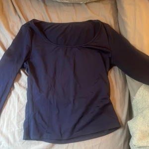 Mörkblå långärmad topp från SHEIN - En stilren mörkblå långärmad topp från SHEIN med rundad halsringning. Toppen är figurnära och har en enkel, klassisk design som passar till många olika outfits. Tillverkad i ett mjukt och stretchigt syntetmaterial för en bekväm känsla.