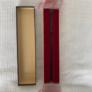 Harry Potter trollstav  - Säljer en detaljerad Harry Potter-trollstav i mörkbrunt träutseende, ca 35 cm lång. Kommer i en snygg ask med röd samet. Har en liten spricka men det är inget man lägger märke till