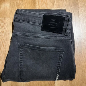 Svarta jeans från Neuw - Säljer ett par svarta slim jeans från Neuw med klassisk femficksdesign och diskret logga på bakfickan. Jeansen har en smal passform och är tillverkade i stretchigt bomullsmaterial för extra komfort. Perfekta för dig som gillar en stilren look. Byxorna är väldigt sparsamt använda därav i superbra skick😊 
