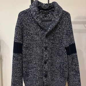 Mörkblå stickad kofta från Banana Republic - Säljer en chunky mörkblå och vitmelerad stickad kofta från Banana Republic. Koftan har stora knappar, chill höst- eller vinterstil.