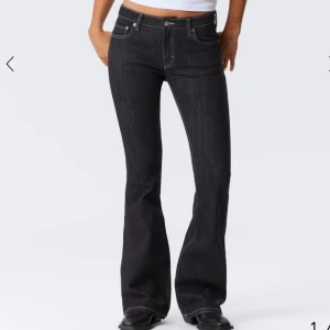 Svarta bootcut jeans från Weekday - (W26 L 32 )Snygga svarta jeans från Weekday med bootcut passform och kontrastsömmar. Klassisk femficksmodell, låg midja och tydlig logopatch bak. Jeansen är tillverkade i slitstarkt denim och har en stilren look som passar perfekt till sneakers eller boots. Använd 1 gång