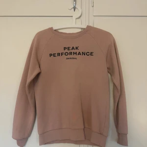 Rosa sweatshirt från Peak Performance - Säljer en snygg rosa sweatshirt från Peak Performance med svart tryck framtill. 