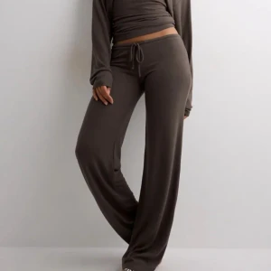 Nelly my chill pants - Mysiga bruna mjukisbyxor med vida ben och snörning i midjan. De är lågmidjade i stolek XS.