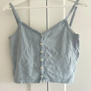 Ljusblå linnetopp - Säljer en ljusblå croppad linnetopp med smala axelband och v-ringning framtill. Storlek onesize men skulle säga S/M och uppåt. 