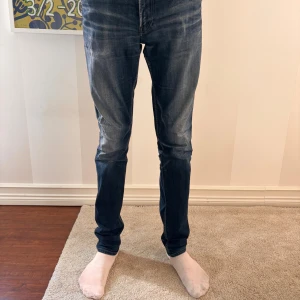 Blå Replay jeans slim fit 32/34 - Snygga blå jeans från Replay i klassisk tvätt med slitningar och smal passform. Jeansen har normal midja och raka ben, tillverkade i bomull för en skön känsla. Perfekta för dig som gillar en stilren och modern look. Pris går alltid att diskutera😁