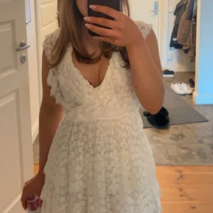 Vit spetsklänning med volanger - Säljer denna jättefina klänning från Nelly, perfekt till studenten/sommaren. Fint skick, endast använd en gång. Storlek, XXS. 450 kr + frakt💖