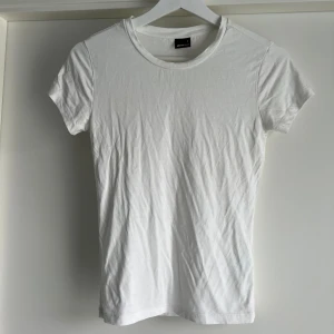 Vit soft touch t-shirt från Gina Tricot - En klassisk vit spft touch t-shirt från Gina Tricot i storlek S. T-shirten har rund halsringning och korta ärmar. Tillverkad i mjuk och stretchig viskosblandning som sitter skönt mot kroppen. Perfekt basplagg till garderoben.