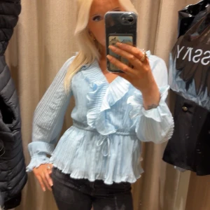 Ljusblå volangblus  - Supersöt ljusblå blus med volangdetaljer 