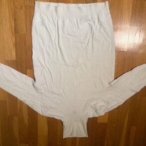Vit slim långtröja från H&M - Säljer en vit långtröja från H&M i slim fit-modell. Kjolen är enkel och stilren med ribbad midja och mjukt bomullsmaterial. Perfekt för dig som gillar minimalistisk och clean stil. 