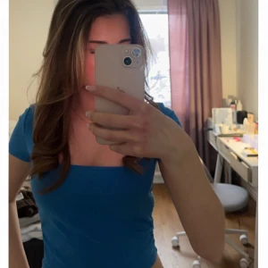 Blå topp med fyrkantig halsringning - Snygg blå topp från Zara med korta ärmar och en fyrkantig halsringning. Modellen är slim, perfekt för dig som gillar en enkel tröja men ändå färgglad.