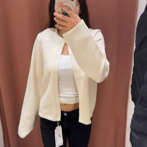 Gina Tricot Vit kofta med ribbade kanter - Säljer en stilren vit kofta från Gina Tricot med ribbade kanter och en knapp vid halsringen💞