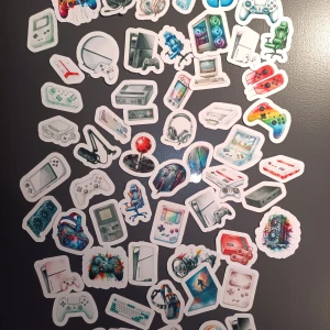 Stickerpaket med retro och moderna spelkonsoler - Unikt stickerpaket med motiv av klassiska och moderna spelkonsoler, handkontroller, gamingtillbehör och datorer. Perfekt för att dekorera laptops, mobiler eller väggar. Färgglada och detaljerade illustrationer. Alla stickers är i nyskick utan synligt slitage.