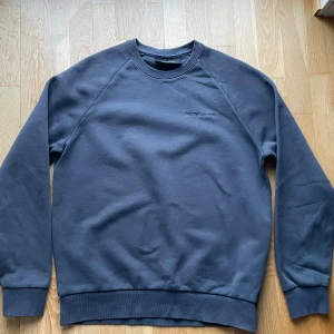 Mörkblå Peak Performance sweatshirt - Snygg mörkblå sweatshirt från Peak Performance med diskret broderad logga på bröstet. Tröjan har rund hals, ribbade muddar och är tillverkad i mjuk bomull. Perfekt för höstens/vinterns chill dagar.