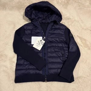 Mörkblå Moncler cardigan med huva - En helt ny moncler cardigan som är mörkblå med svart logga. Den är i storlek M men passar även de som har storlek S.                                Pris kan diskuteras vid snabb affär!!