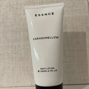 Essnce - Carashmellow Body Lotion 200 ml - Essnce Carashmellow Body Lotion i en stilren vit tub med svart text och svart lock. Innehåller 200 ml och har en söt, marshmallow-liknande doft. Perfekt för att återfukta huden och ge en mjuk känsla. Endast använd 2-3 ggr :) bianco latte inspirerad doft. 