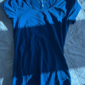 Blå t-shirt från No365, XS - Snygg blå t-shirt från No365 i storlek XS. Modellen har rund halsringning och korta ärmar. Materialet är mjuk bomull som känns skönt mot huden. Perfekt för dig som gillar enkla och stilrena basics i garderoben.