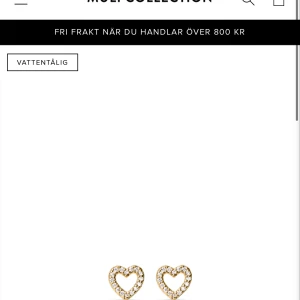 Guldiga hjärtformade örhängen med pärlor från Muli - Supersöta örhängen i guld med hjärtformad design från Muli, dekorerade med små glittrande pärlor runt hela kanten. Perfekta för att ge din look lite extra shine och romantisk vibe. Små och diskreta men ändå riktigt fina detaljer. Ordinarie 299kr, pris 200kr