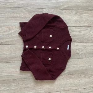 Vinröd kofta  - Superfin croppad kofta i mörk vinröd färg från meet me there. Perfekt nu till hösten och vintern. Köpt för ca 400kr