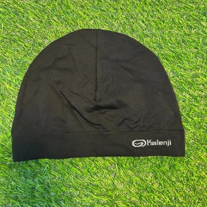 Svart träningsmössa från Kalenji - En stilren svart mössa från Kalenji, perfekt för träning utomhus. Tillverkad i ett lätt och stretchigt syntetmaterial som andas. Enkel design med diskret logga framtill. Sitter tajt på huvudet och funkar grymt när du vill hålla värmen under löprundan.