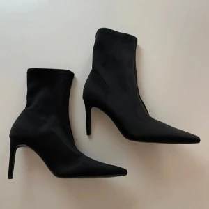 Nya Stradivarius stövletter, Storlek 41 med prislapp - Snygga svarta stövletter från Stradavarius med spetsig tå och hög klack. Perfekta för att klä upp en outfit.