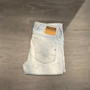 Replay anbass ljusblå  - Säljer ett par Replay jeans i ljusblå tvätt med klassisk femficksdesign och bruna detaljer på bakfickan. är tillverkade i mjukt jeanstyg med snygga slitningar för en cool look.                                                                                                            Finns någre defekter där av pris