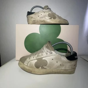 Beige sneakers från The Gallerist - Snygga beige sneakers från The Gallerist i stl 38. Perfekt nu till hösten, med mockadetaljer, och den klassiska klövern på sidan av skon. Box medföljer! Skriv om ni har frågor eller om ni vill förhandla!