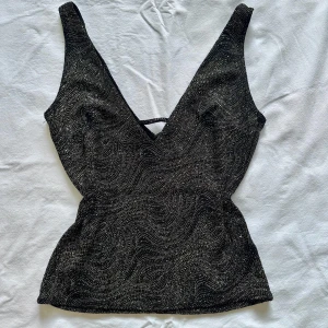 Topp - Glittrig topp med djupare urringning, vid köp av flera varor får du rabatt 💛