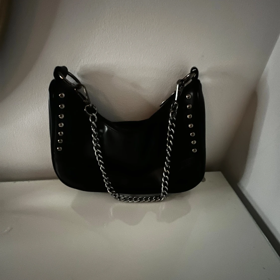 Svart axelväska med kedja och nitar