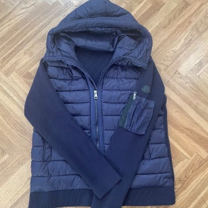 Moncler cardigan marinblå med svart märke - En jätte fin moncler cardigan som ej har kommit till användning. Allt är bra med den också den har aldrig använts, inga byten endast försäljning