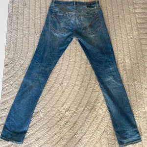 Dondup - Snygga blå jeans från Dondup med klassisk femficksdesign och slitna detaljer. Jeansen har en smal passform och är tillverkade i stretchigt denim för en bekväm känsla. Perfekta för dig som vill ha ett par stilrena jeans i garderoben. Lite slitna, därav det billiga priset😁 hör av er vid frågor🌟