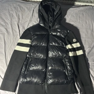 Svart Moncler cardigan - Säljer nu min svart pufferjacka från Moncler .  Inga problem me jackan, hör av dig om du har några funderingar kring jackan. Storleken på jackan är L