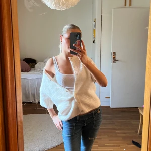 Vit stickad kofta med knappar - Säljer en vit stickad kofta från Gina med ribbad struktur och snygga knappar framtill. Koftan har en lite loose passform och trekvartsärm. Enkel och fräsch look som funkar året runt. Den är endast använd en gång så så gott som ny 💕